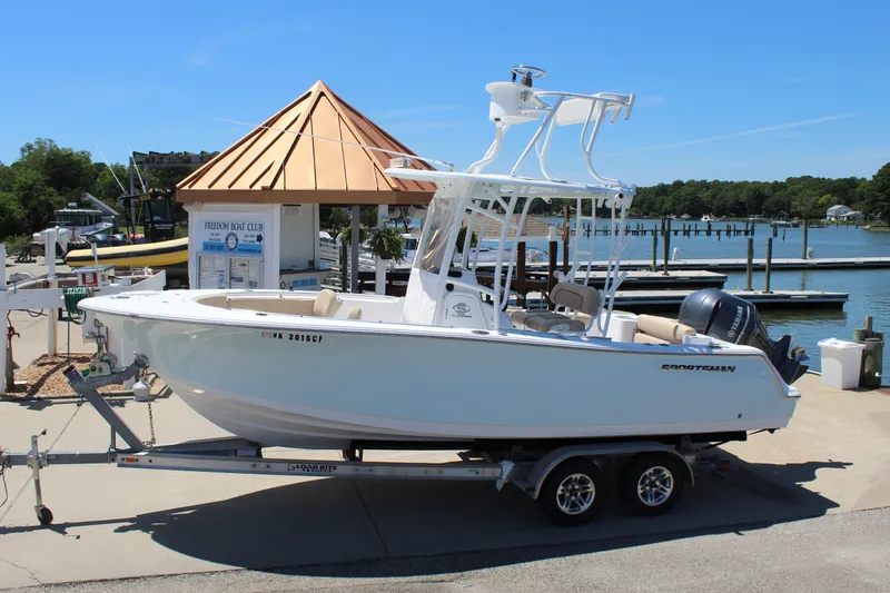 Slide: The Image of A 2019 Sportsman Open 232 Center Console boat on a trailer at a marina. - 4
