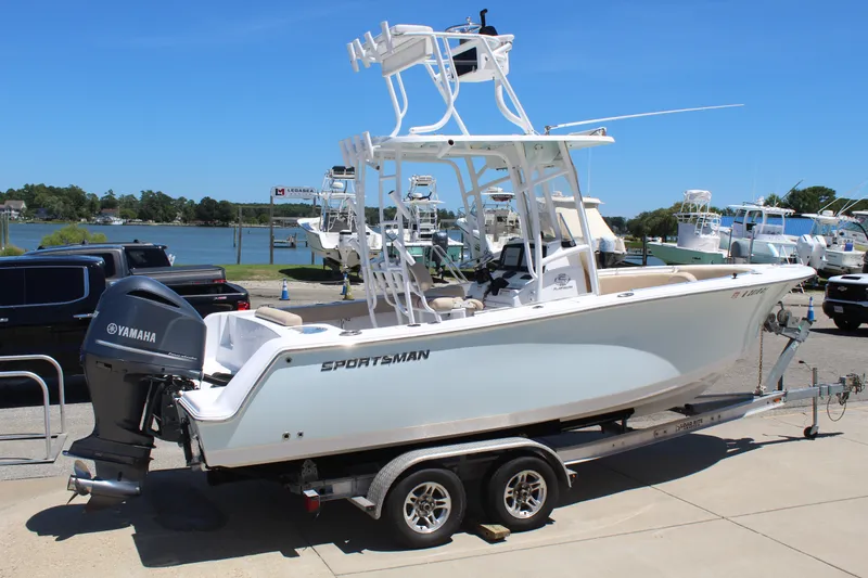 Slide: The Image of A 2019 Sportsman Open 232 Center Console boat on a trailer in a marina setting. - 0