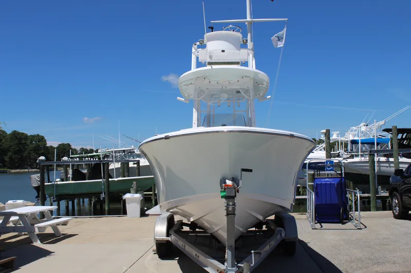Slide: The Image of A 2019 Sportsman Open 232 Center Console boat on a trailer at a marina. - 2