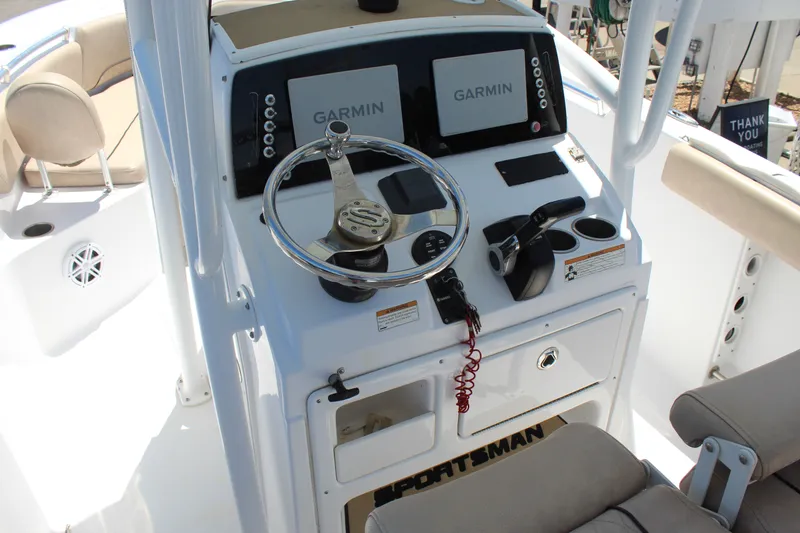 Slide: The Image of The image shows the helm of a 2019 Sportsman Open 232 Center Console boat with Garmin screens. - 16