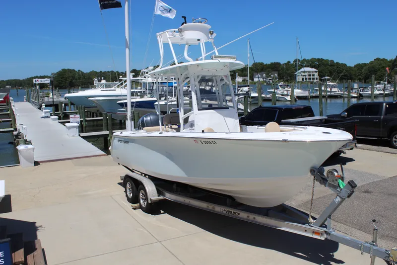 Slide: The Image of A 2019 Sportsman Open 232 Center Console boat on a trailer at a marina. - 1
