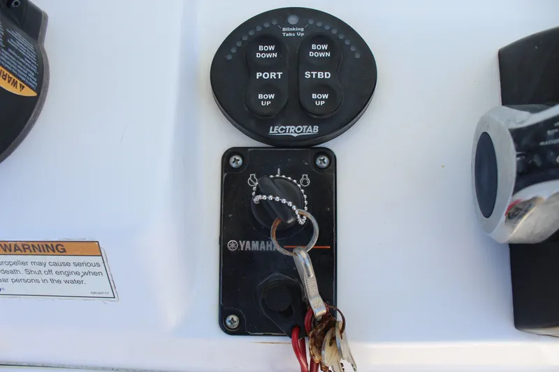 Slide: The Image of Close-up of a control panel with Yamaha ignition key and Lenco trim tab control. - 26