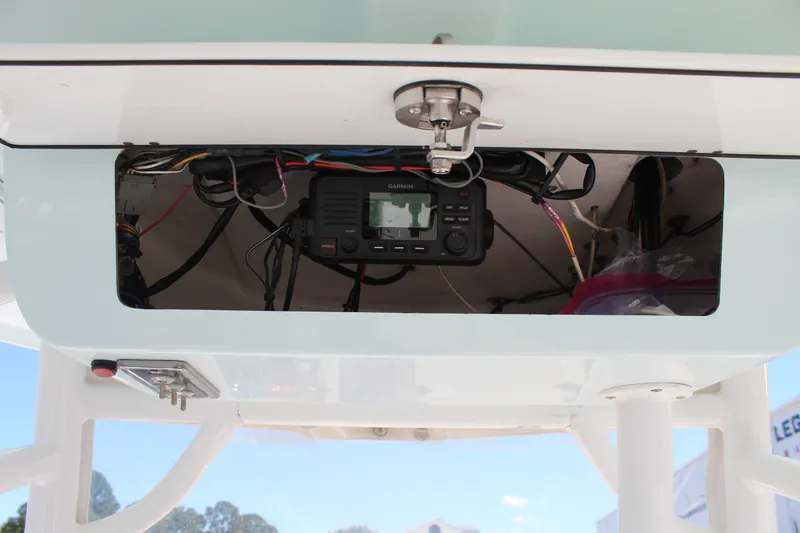 Slide: The Image of An open electronics compartment with a Garmin device and wires in the Sportsman Open 232 Center Console boat. - 27