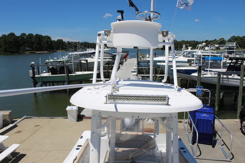 Slide: The Image of A 2019 Sportsman Open 232 Center Console boat docked alongside other boats. - 19