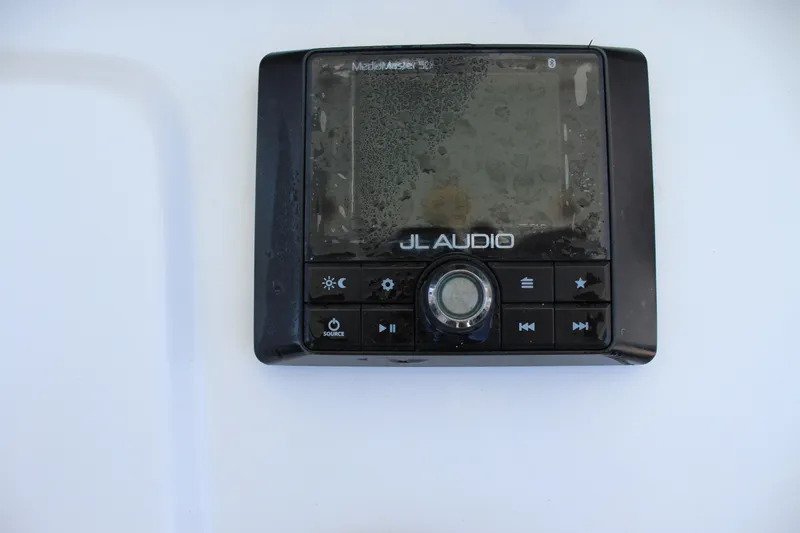Slide: The Image of A JL Audio MediaMaster control unit with multiple buttons and a dial on a white background. - 25