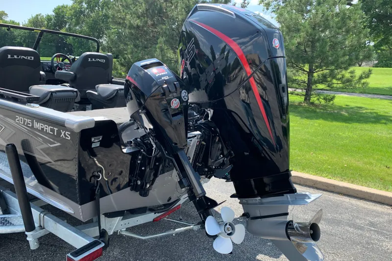 Slide: The Image of 2025 Lund 2075 Impact XS boat with powerful outboard motor, parked on a trailer. - 14