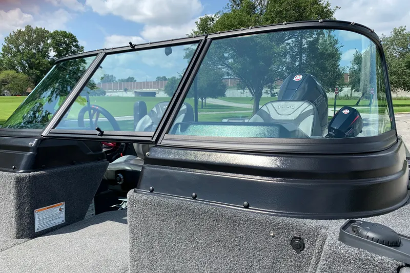 Slide: The Image of 2025 Lund 2075 Impact XS boat with windshield, parked outdoors on a sunny day. - 22