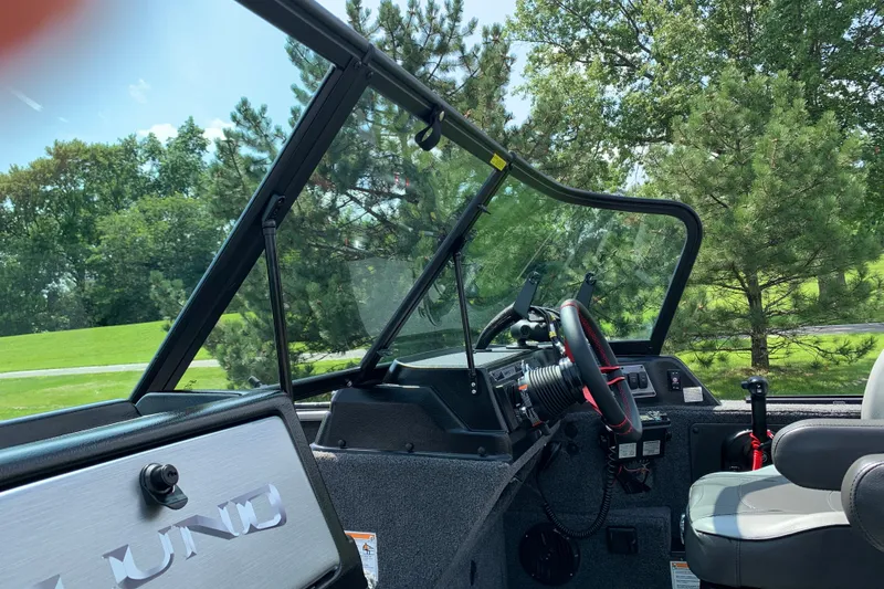 Slide: The Image of Interior view of 2025 Lund 2075 Impact XS boat with steering wheel and seating. - 21