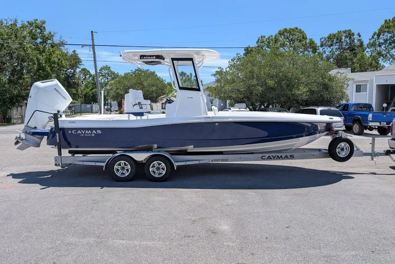 The Image of 2027 Caymas 26 HB boat on trailer, parked outdoors, featuring sleek design and powerful engine. - 0