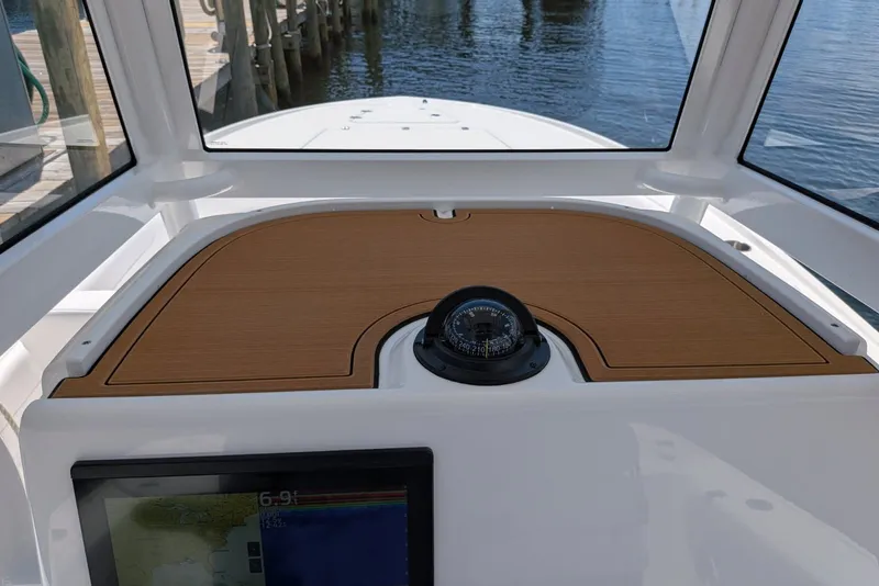 Slide: The Image of 2027 Caymas 26 HB boat dashboard with compass and navigation display. - 10