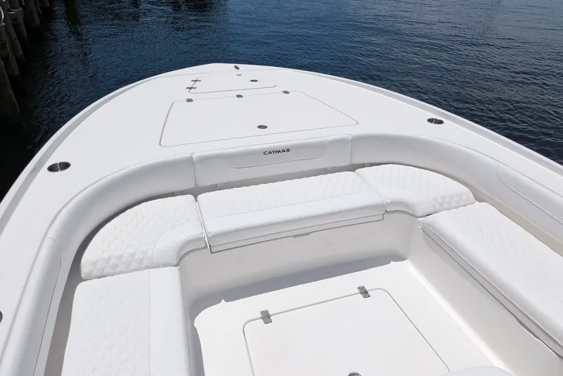 Slide: The Image of 2027 Caymas 26 HB boat with white seating, docked by calm water. - 6