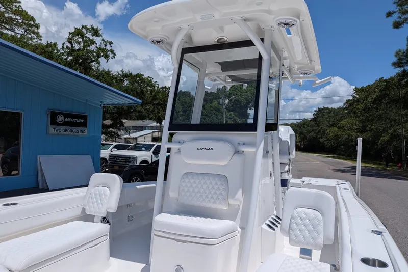 Slide: The Image of 2027 Caymas 26 HB boat with white seating and console, parked outdoors under a blue sky. - 4