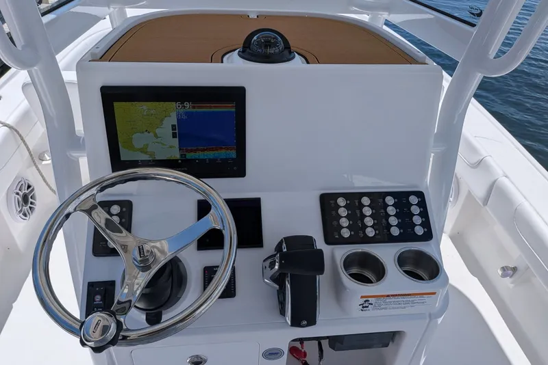 Slide: The Image of Helm of 2027 Caymas 26 HB boat with steering wheel, controls, and navigation display. - 9