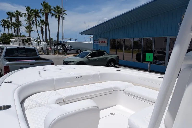 Slide: The Image of 2027 Caymas 26 HB boat with white seating, parked near a dealership under a sunny sky. - 5