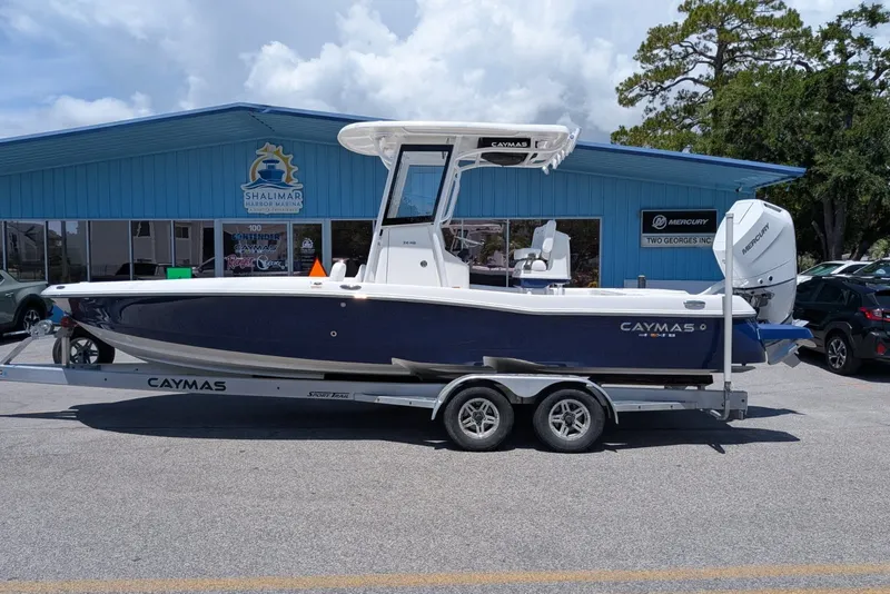 Slide: The Image of 2027 Caymas 26 HB boat on trailer at Shalimar Harbor Marina, blue exterior. - 1