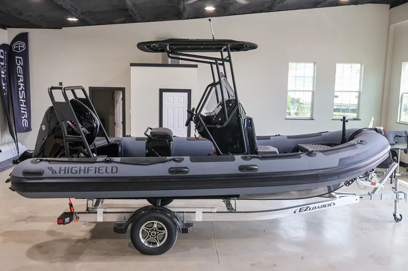 The Image of 2026 Highfield Patrol 540 boat on trailer in showroom setting. - 1