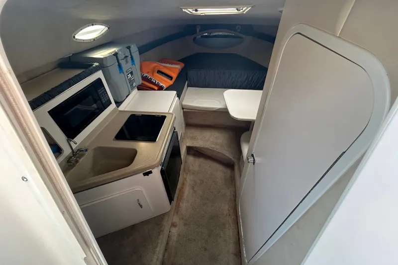 Slide: The Image of Interior of 2002 Wellcraft 2600 Martinique boat with kitchenette and seating area. - 3