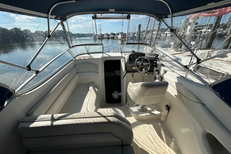 Slide: The Image of 2002 Wellcraft 2600 Martinique boat interior with helm, seating, and waterfront view. - 2