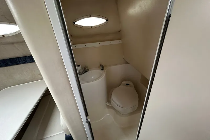 Slide: The Image of 2002 Wellcraft 2600 Martinique boat bathroom with compact toilet and sink. - 9