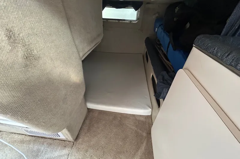 Slide: The Image of 2002 Wellcraft 2600 Martinique cabin interior with bed and storage space. - 6