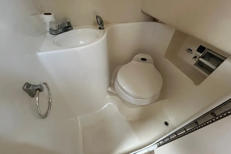 Slide: The Image of Compact bathroom in 2002 Wellcraft 2600 Martinique boat, featuring toilet and sink. - 10