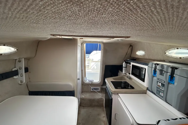 Slide: The Image of Interior of 2002 Wellcraft 2600 Martinique boat with kitchenette and seating area. - 5