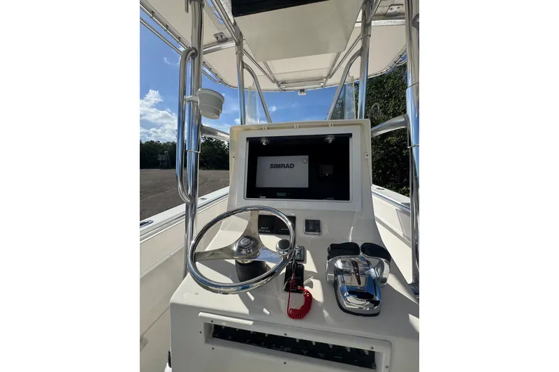 Slide: The Image of 2003 Contender 25 Open boat console with steering wheel and Simrad display. - 50