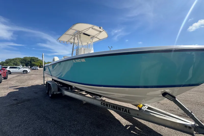 Slide: The Image of 2003 Contender 25 Open boat on trailer under clear blue sky. - 5