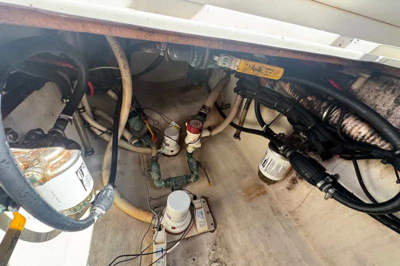 Slide: The Image of Engine compartment of a 2003 Contender 25 Open boat, showing hoses and filters. - 46