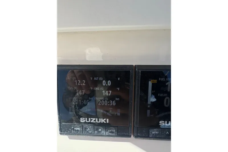 Slide: The Image of Suzuki engine display on a 2003 Contender 25 Open boat dashboard. - 52