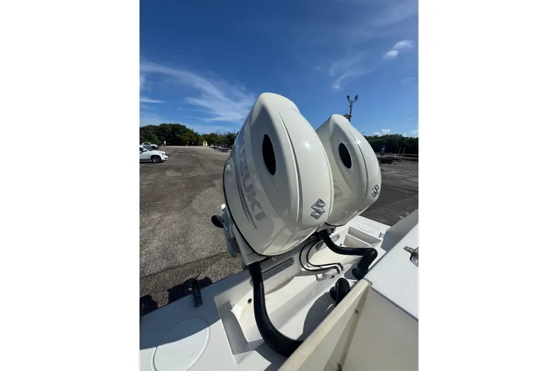 Slide: The Image of Twin Suzuki outboard motors on a 2003 Contender 25 Open boat under a clear blue sky. - 37