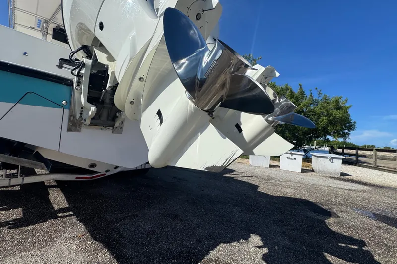 Slide: The Image of 2003 Contender 25 Open boat with dual outboard engines and shiny propellers. - 30