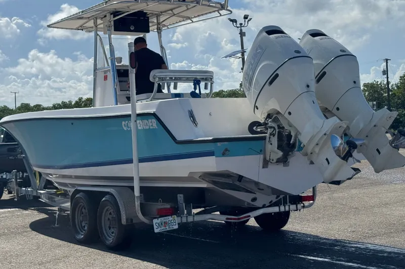Slide: The Image of 2003 Contender 25 Open boat on trailer with dual outboard engines. - 18