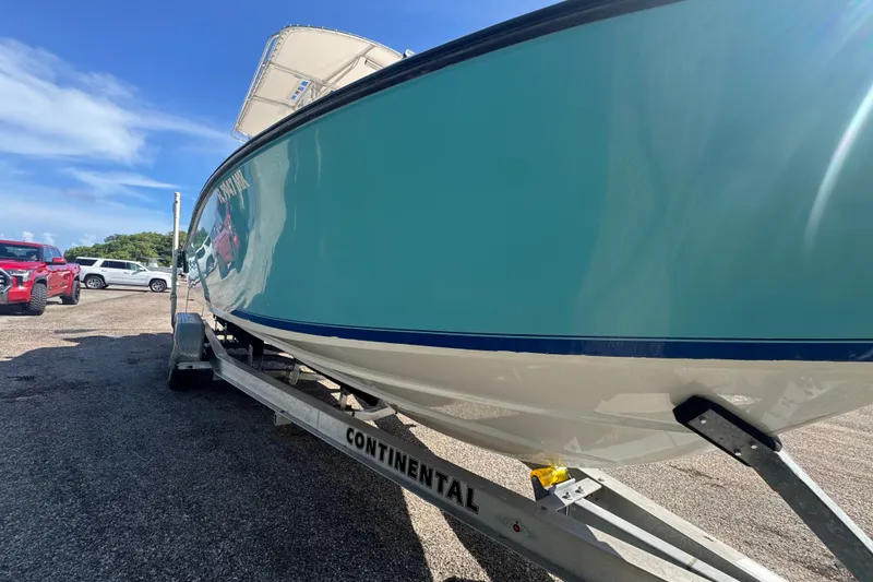 Slide: The Image of 2003 Contender 25 Open boat on trailer, parked outdoors under clear blue sky. - 8