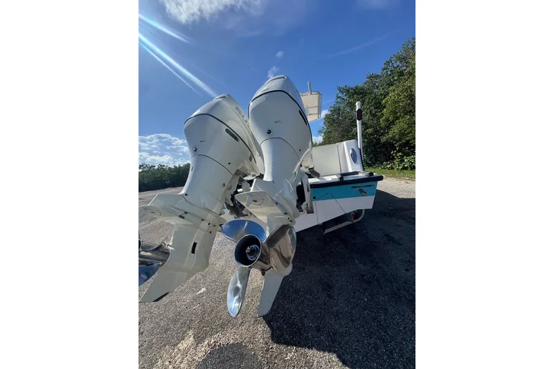 Slide: The Image of 2003 Contender 25 Open boat with dual outboard motors under a clear blue sky. - 10