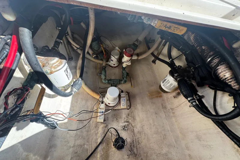 Slide: The Image of Engine compartment of a 2003 Contender 25 Open boat, showing hoses and filters. - 47