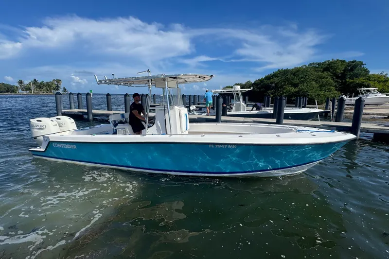 Slide: The Image of 2003 Contender 25 Open boat with Suzuki engines docked on a sunny day. - 21