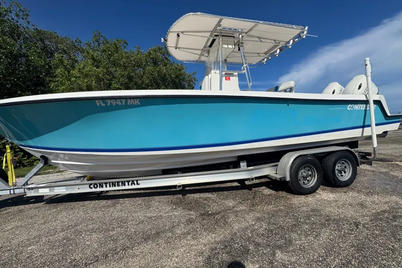 Slide: The Image of 2003 Contender 25 Open boat on trailer, blue hull, sunny day. - 4