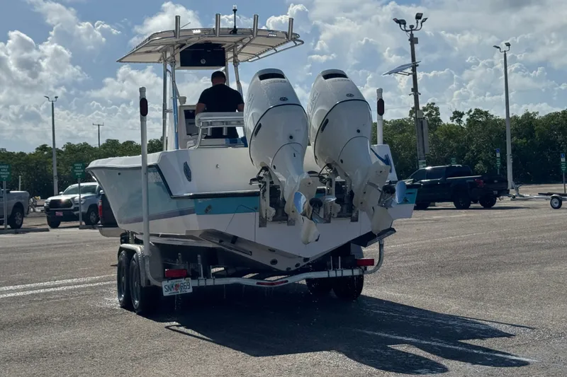 Slide: The Image of 2003 Contender 25 Open boat on trailer with dual engines in parking lot. - 28