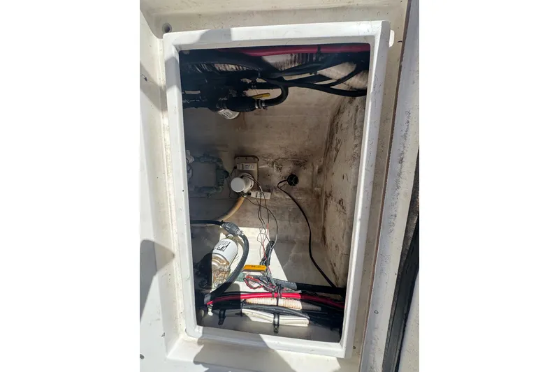 Slide: The Image of Open compartment of a 2003 Contender 25 Open boat, showing internal wiring and components. - 44