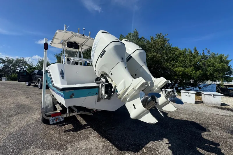 Slide: The Image of 2003 Contender 25 Open boat with dual outboard motors on a trailer. - 11
