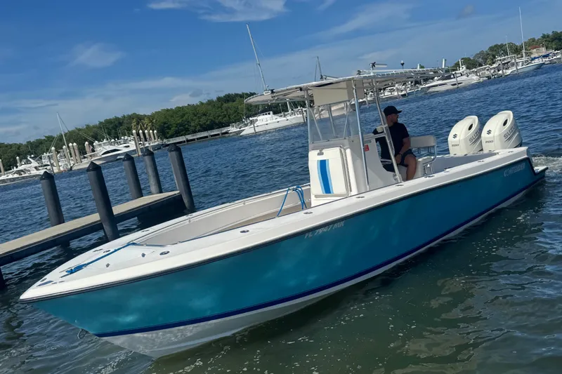 Slide: The Image of 2003 Contender 25 Open boat with dual engines on a sunny day at the marina. - 19