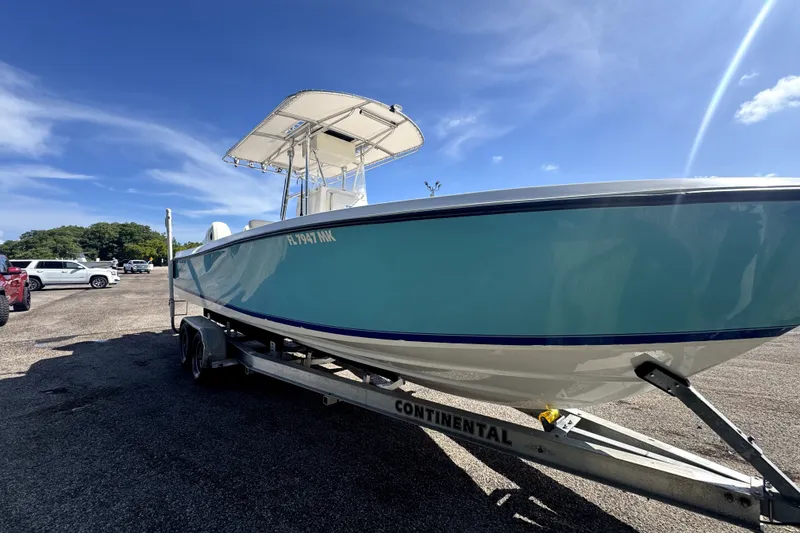 Slide: The Image of 2003 Contender 25 Open boat on trailer under clear blue sky. - 6