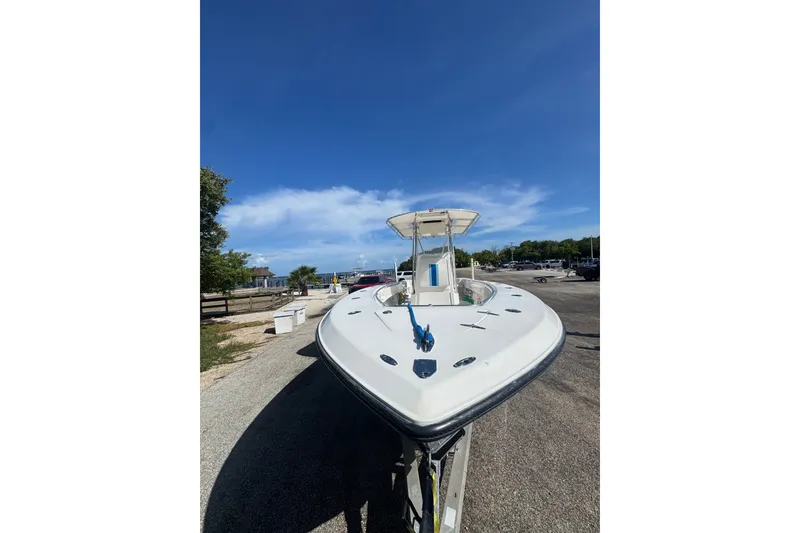 Slide: The Image of 2003 Contender 25 Open boat on trailer under clear blue sky. - 29