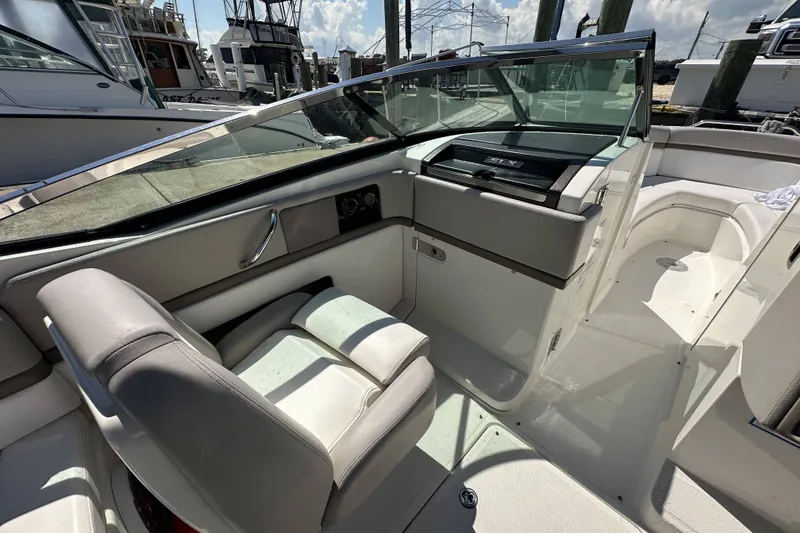 Slide: The Image of 2012 Sea Ray SLX 250 boat interior with sleek seating and modern dashboard. - 12