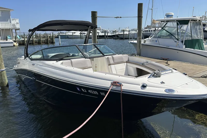 Slide: The Image of 2012 Sea Ray SLX 250 boat docked at marina, featuring sleek design and spacious seating. - 18
