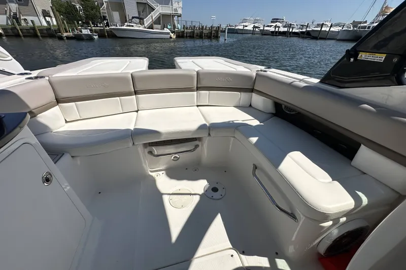 Slide: The Image of 2012 Sea Ray SLX 250 boat interior with white seating, docked at marina. - 4