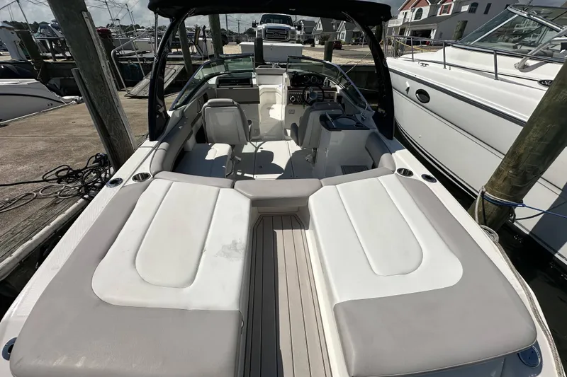 Slide: The Image of 2012 Sea Ray SLX 250 boat interior at marina, featuring spacious seating and sleek design. - 2