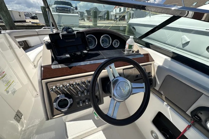 Slide: The Image of Interior view of 2012 Sea Ray SLX 250 boat cockpit with steering wheel and controls. - 11