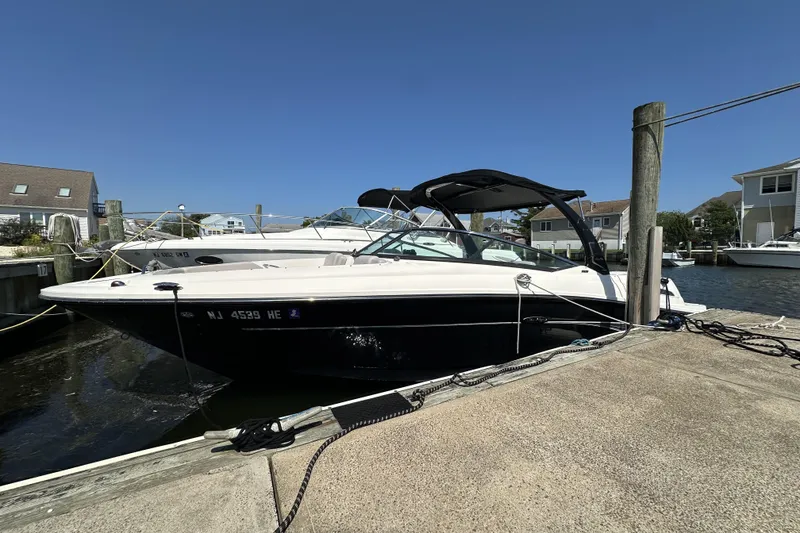 Slide: The Image of 2012 Sea Ray SLX 250 boat docked at marina under clear blue sky. - 15